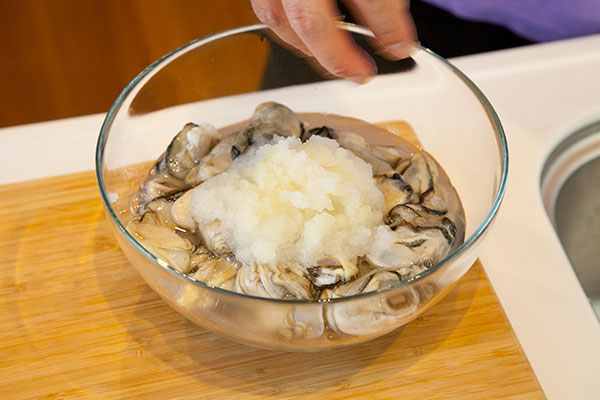 牡蠣の洗い方2　牡蠣を入れたボウルに大根おろしを入れます